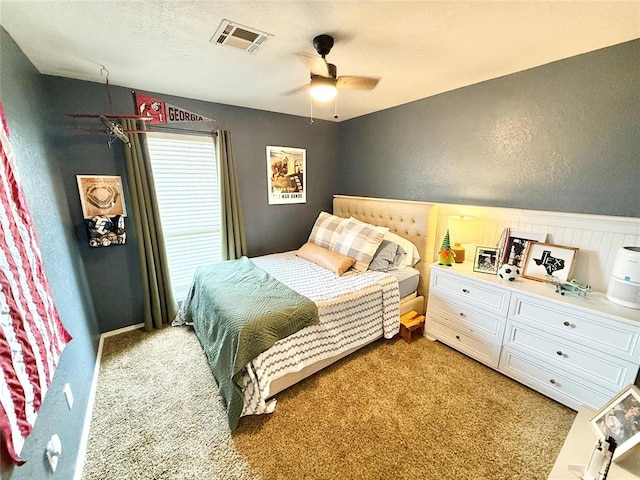 bedroom featuring a textured ceiling, ceiling fan, and carpet