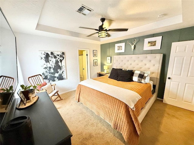 bedroom featuring carpet floors, a raised ceiling, and ceiling fan