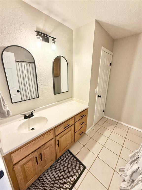 bathroom with vanity, tile patterned flooring, and a textured ceiling