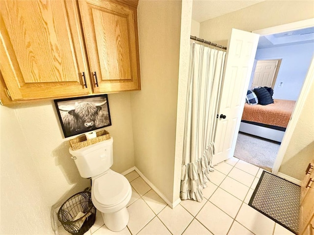 bathroom featuring tile patterned floors, baseboard heating, and toilet