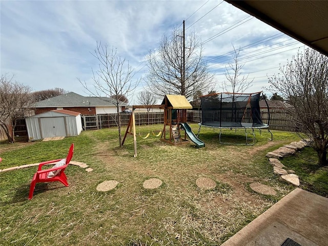 view of playground with a trampoline, a lawn, and a shed