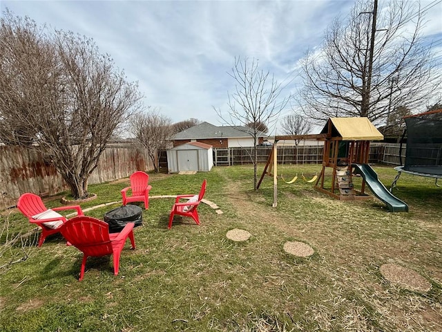 view of play area with a trampoline, a storage shed, and a lawn