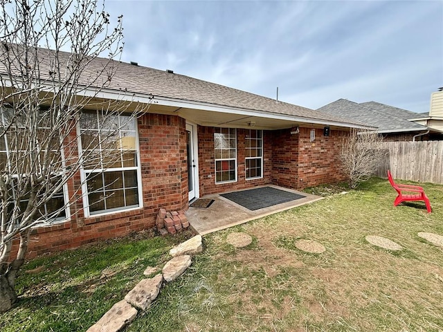 back of property with a patio area and a lawn