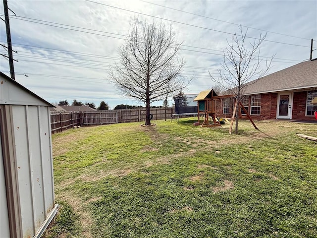 view of yard with a storage shed and a playground