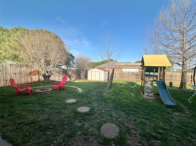 2800 Gettysburg Dr, Altus, OK 73521 - view of yard featuring a playground, a fenced backyard, a storage unit, a fire pit, and an outdoor structure