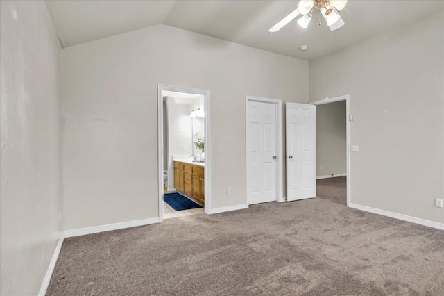 unfurnished bedroom with vaulted ceiling, light colored carpet, ceiling fan, and ensuite bath