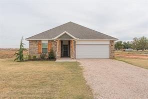 single story home with a garage and a front lawn