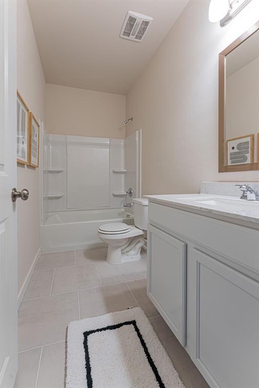 full bath with toilet, vanity, visible vents, shower / bathing tub combination, and tile patterned floors