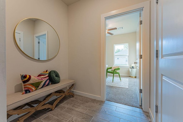 hallway featuring wood finish floors, visible vents, and baseboards