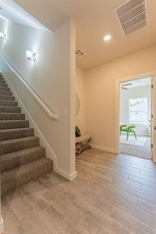 staircase featuring recessed lighting, visible vents, baseboards, and wood finished floors