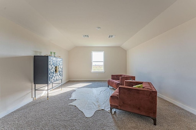 living area featuring visible vents, vaulted ceiling, and baseboards