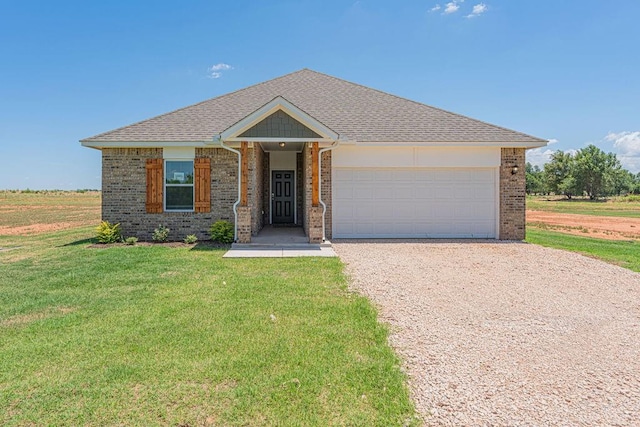 ranch-style home featuring gravel driveway, brick siding, an attached garage, and a front yard