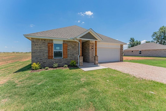 ranch-style home with an attached garage, a front lawn, gravel driveway, and brick siding