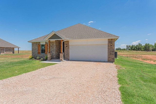 view of front of house with driveway, brick siding, and a front yard