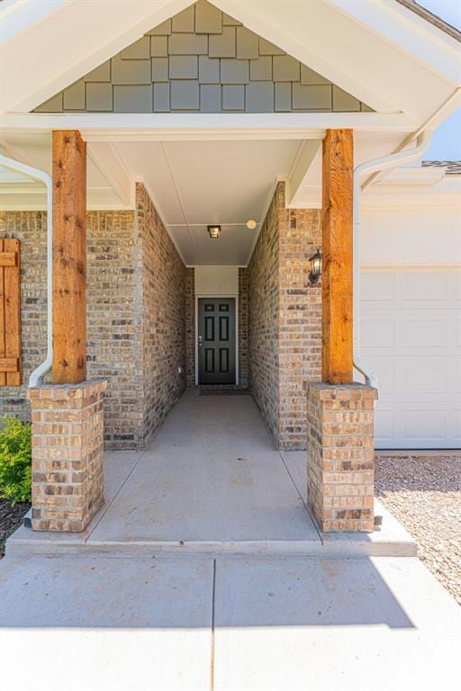 property entrance with a garage and brick siding