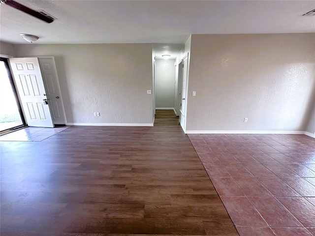 spare room featuring dark wood-type flooring