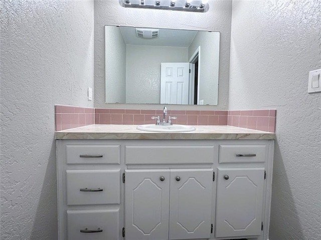 bathroom featuring vanity and backsplash