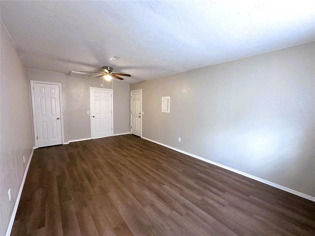 spare room with a textured ceiling, dark wood-type flooring, and ceiling fan