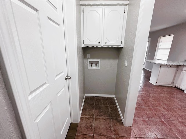 laundry room with hookup for a washing machine, tile patterned floors, and cabinets