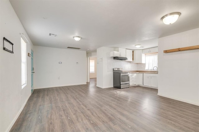 kitchen featuring hardwood / wood-style flooring, tasteful backsplash, white cabinets, and electric stove