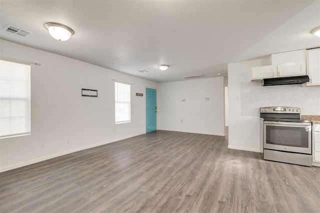 kitchen featuring white cabinets, hardwood / wood-style floors, stainless steel range with electric cooktop, and decorative backsplash