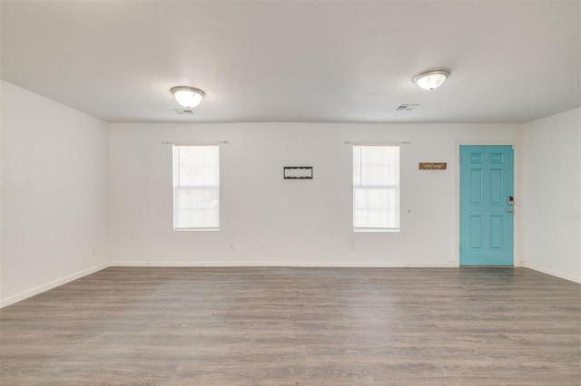 unfurnished room with plenty of natural light and hardwood / wood-style floors