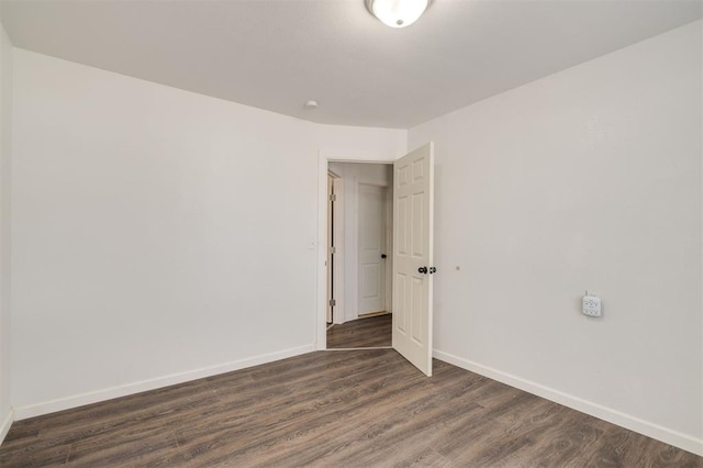 empty room with dark hardwood / wood-style flooring