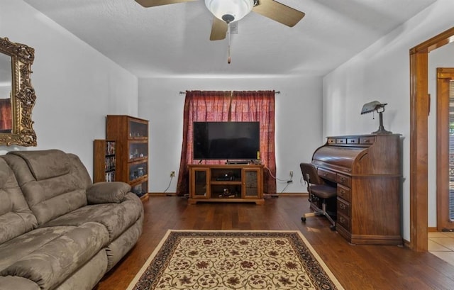 living room featuring dark wood-type flooring and ceiling fan