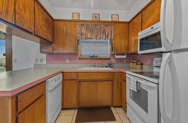 kitchen featuring white appliances, kitchen peninsula, sink, and light tile patterned floors