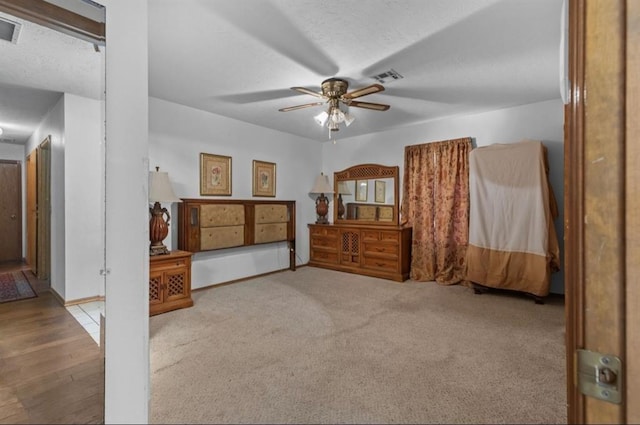 carpeted bedroom with ceiling fan and a textured ceiling