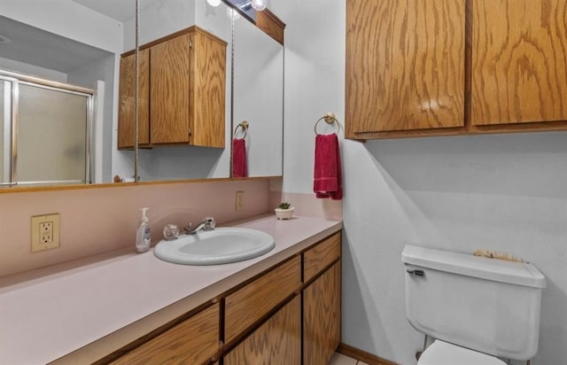 bathroom featuring vanity, toilet, and walk in shower