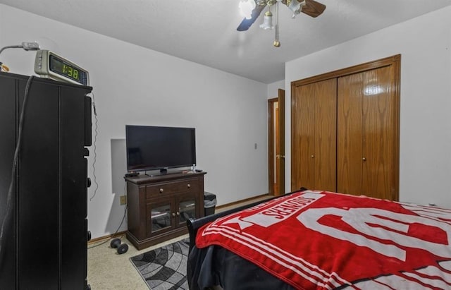 carpeted bedroom featuring ceiling fan and a closet