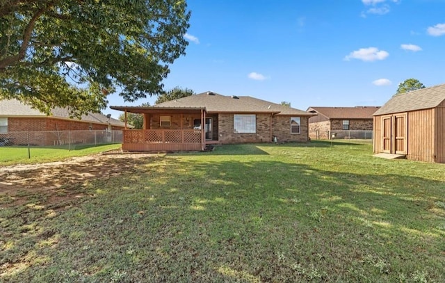 back of house featuring a storage shed and a yard