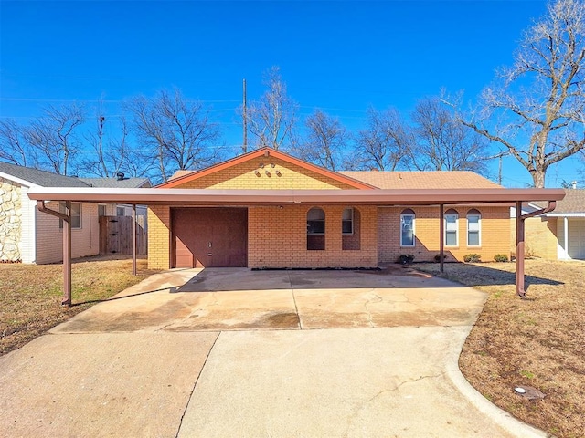 ranch-style home with concrete driveway, brick siding, a garage, and a front lawn