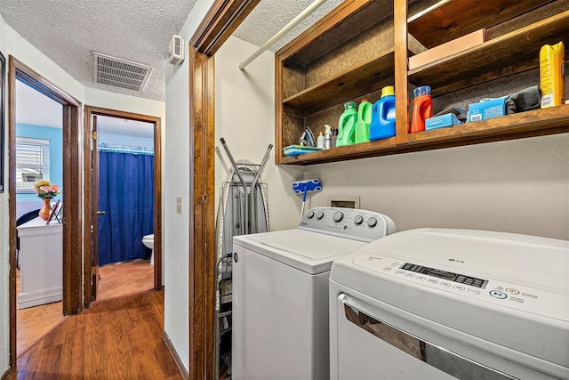 laundry room with dark hardwood / wood-style floors, independent washer and dryer, and a textured ceiling