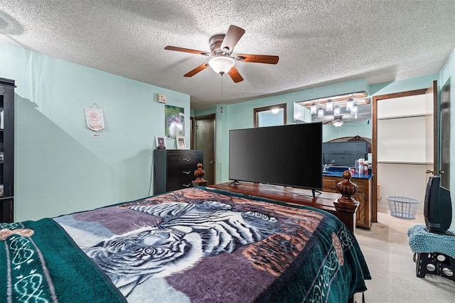 carpeted bedroom with ceiling fan and a textured ceiling