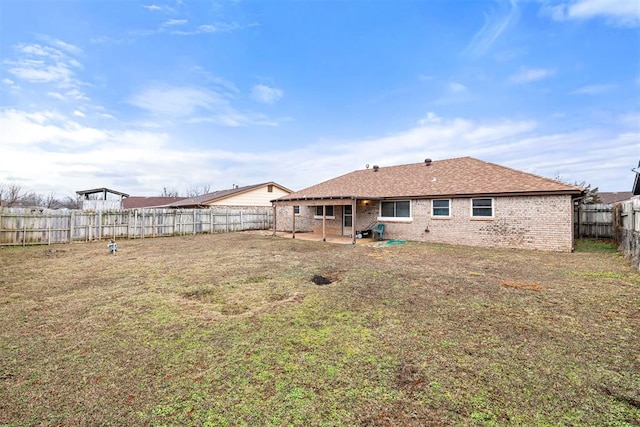 rear view of property featuring a patio and a yard