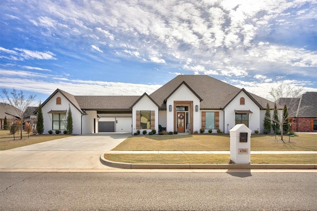 modern farmhouse featuring an attached garage, driveway, and a front yard