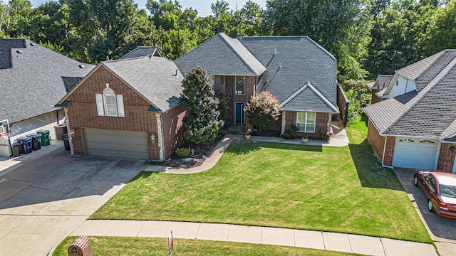 traditional home featuring a garage, a front lawn, concrete driveway, and brick siding