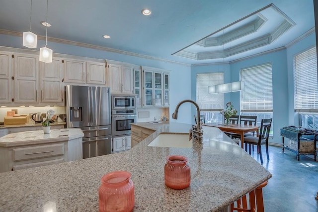 kitchen with sink, appliances with stainless steel finishes, light stone counters, ornamental molding, and decorative light fixtures