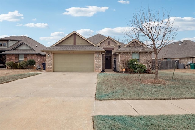 view of front of property with a garage, central AC, and a front yard