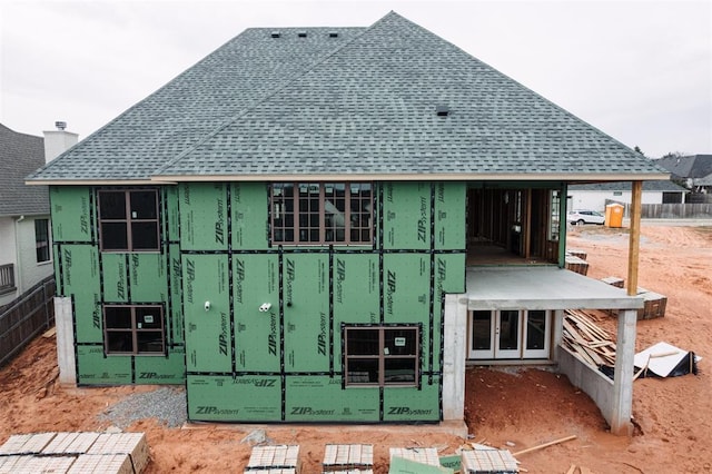 rear view of house with a shingled roof
