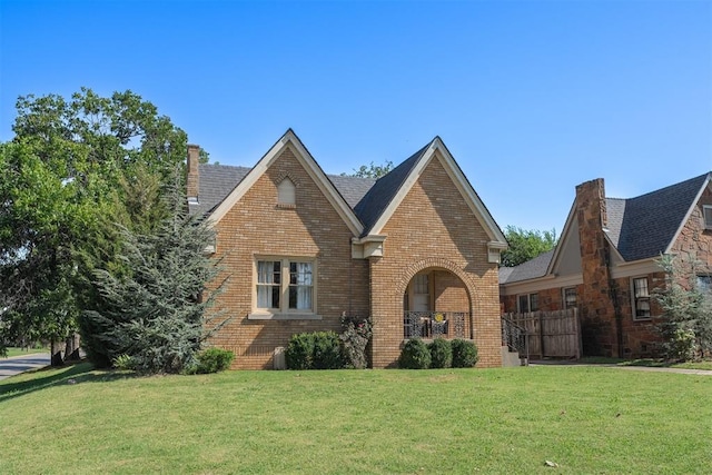 tudor home featuring a front lawn