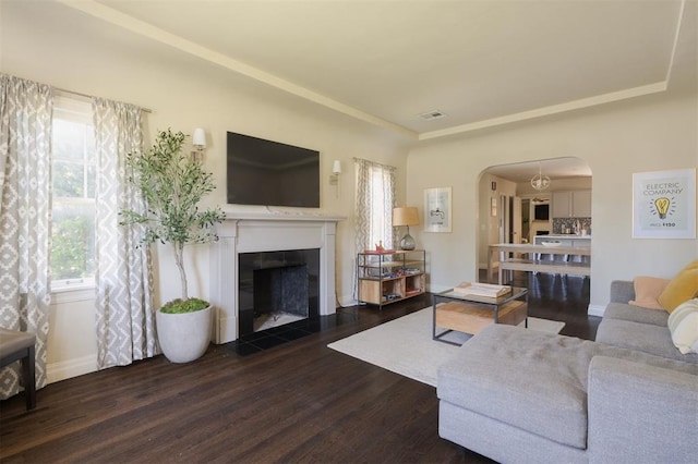 living room with dark wood-type flooring and a tiled fireplace