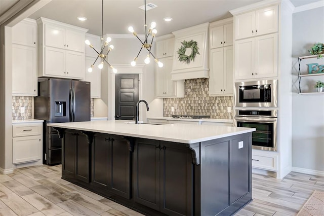 kitchen featuring visible vents, a sink, stainless steel appliances, white cabinets, and light countertops