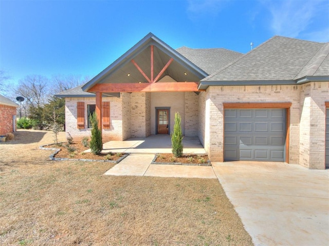 817 Carrie Ct, Purcell, OK 73080 - view of front of home featuring brick siding, a porch, a garage, and roof with shingles