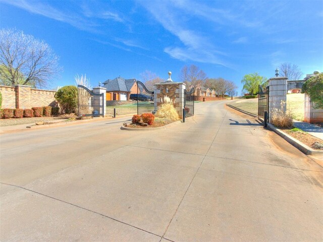 817 Carrie Ct, Purcell, OK 73080 - view of street featuring a gated entry, curbs, street lights, and a gate