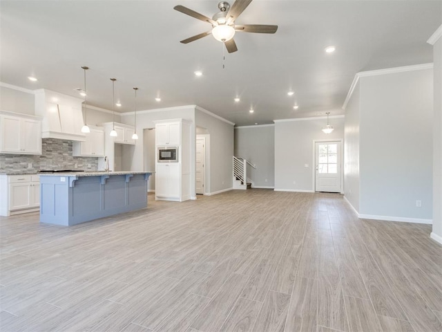 817 Carrie Ct, Purcell, OK 73080 - kitchen with ceiling fan, built in microwave, open floor plan, decorative backsplash, and white cabinetry