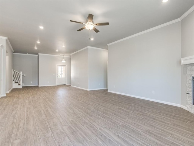 817 Carrie Ct, Purcell, OK 73080 - unfurnished living room featuring a stone fireplace, a ceiling fan, light wood-type flooring, and baseboards