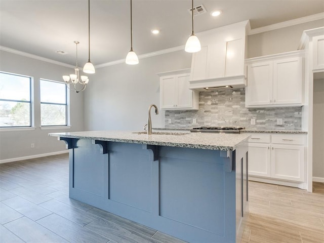 817 Carrie Ct, Purcell, OK 73080 - kitchen featuring visible vents, ornamental molding, a sink, white cabinets, and decorative backsplash